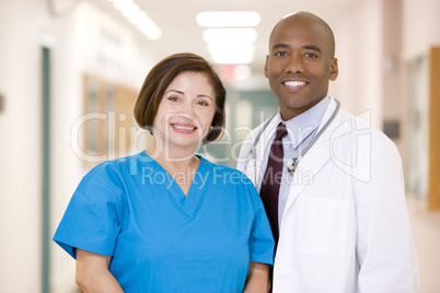 A Doctor And Nurse Standing In A Hospital Corridor