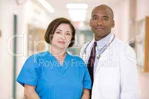 A Doctor And Nurse Standing In A Hospital Corridor