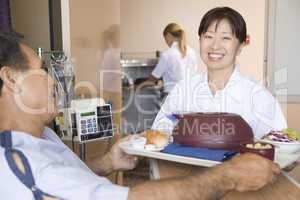 Nurse Serving A Patient A Meal In His Bed