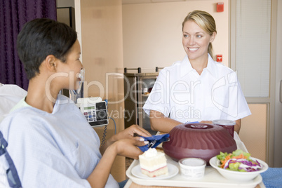 Nurse Serving A Patient A Meal In Her Bed