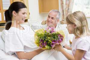 Young Girl Giving Flowers To Her Mother In Hospital