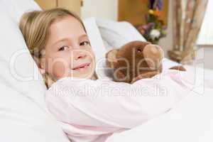 Young Girl Lying In Hospital Bed,Holding Teddy Bear