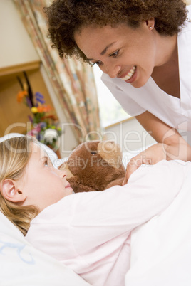Nurse Checking Up On Young Girl In Hospital