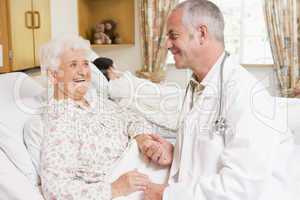 Doctor Laughing With Senior Woman In Hospital