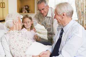 Family Sitting With Senior Woman In Hospital