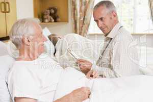 Doctor Checking Up On Senior Man In Hospital