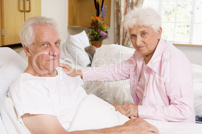 Senior Couple Sitting In Hospital,Looking Serious