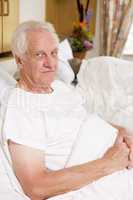 Senior Man Sitting In Hospital Bed