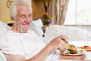 Senior Man Eating Hospital Food In Bad