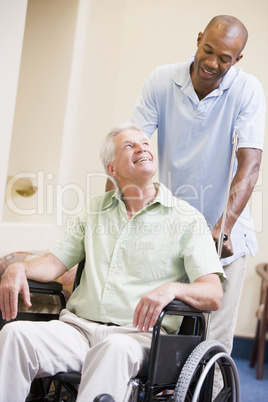 Nurse Pushing Man In Wheelchair