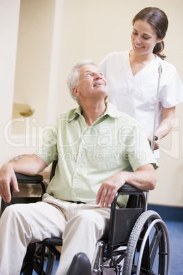 Nurse Pushing Man In Wheelchair
