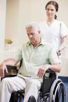 Nurse Pushing Man In Wheelchair