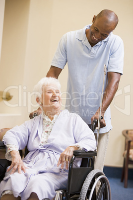 Nurse Pushing Senior Woman In Wheelchair
