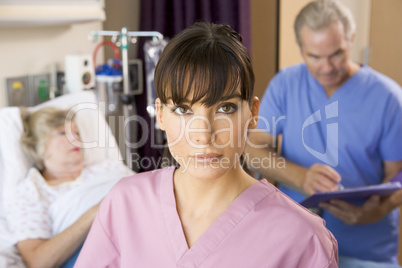 Nurse Standing In Hospital Room,Doctor Making Notes About Patien