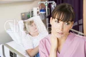 Nurse Standing In Hospital Room,Looking Tired