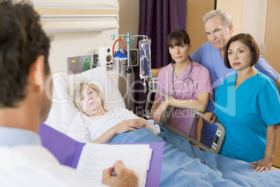 Doctor Making Notes On Patient
