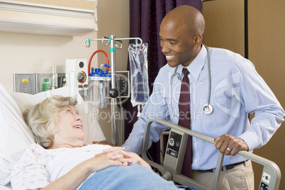 Doctor Talking To Senior Woman Lying In Hospital Bed