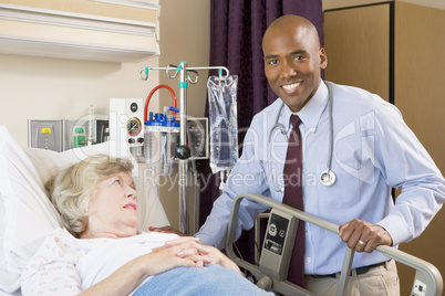 Doctor Checking Up On Patient Lying In Hospital Bed