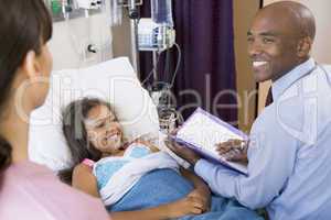 Doctor Making Notes On Young Girl