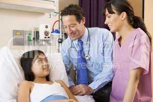 Doctor And Nurse Talking To Young Girl