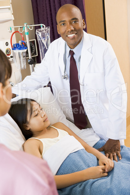 Doctor Standing In Hospital Room With Patient
