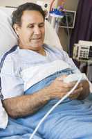 Middle Aged Man Pressing The Call Button In Hospital