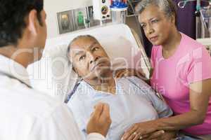 Senior Couple Talking To Doctor,Looking Worried