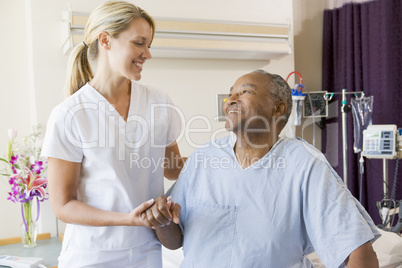 Nurse Helping Patient Sit Up In Bed