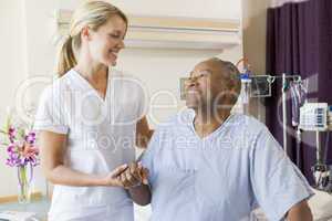 Nurse Helping Patient Sit Up In Bed