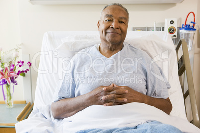 Senior Man Sitting In Hospital Bed