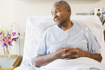 Senior Man Sitting In Hospital Bed