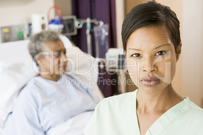 Nurse Standing In Patients Room Looking Serious