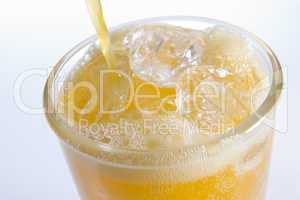 Pouring Orangeade Into A Glass Of Ice