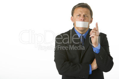 Businessman With His Mouth Taped Shut And Pointing
