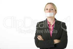 Businesswoman With Her Arms Folded And Mouth Taped Shut