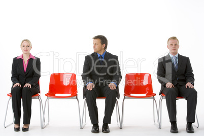 Three Business People Sitting On Red Plastic Seats