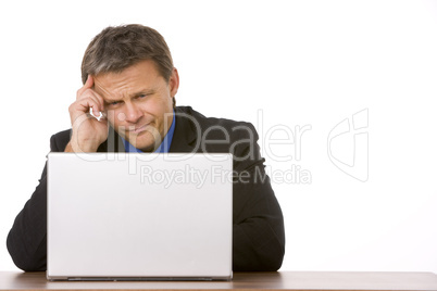 Businessman Frowning While Looking At Laptop