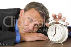 Businessman Leaning On Desk Watching Clock