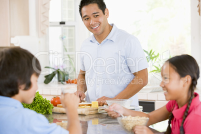 Children Having Breakfast While Dad Prepares Food