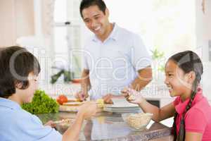 Children Having Breakfast While Dad Prepares Food