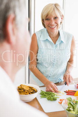 Woman Talking To Husband As She Prepares A meal,mealtime