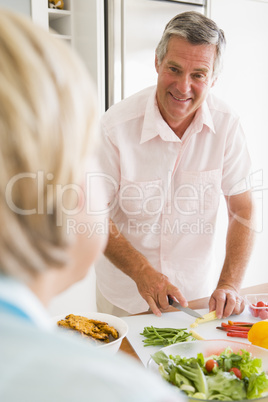 Husband Talking To Wife While Preparing meal,mealtime