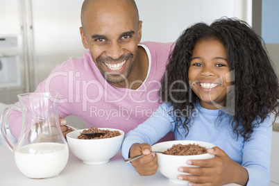 Father Sitting With Daughter As She They Eat Breakfast