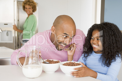 Father Sitting With Daughter As She They Eat Breakfast With Her