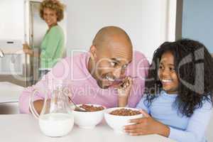 Father Sitting With Daughter As She They Eat Breakfast With Her