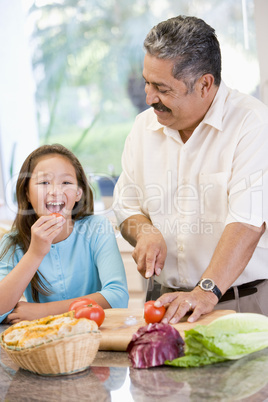 Grandfather And Granddaughter Preparing meal,mealtime Together