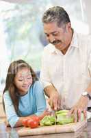 Grandfather And Granddaughter Preparing meal,mealtime Together