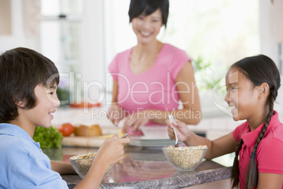 Children Enjoying Breakfast While Mother Is Preparing Food