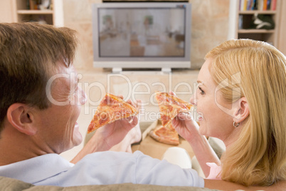 Couple Enjoying Pizza In Front Of TV