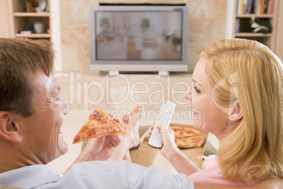 Couple Enjoying Pizza In Front Of TV